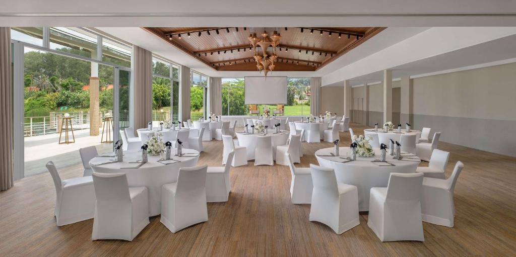 a banquet hall with white tables and white chairs at Banyan Tree Phuket in Bang Tao Beach