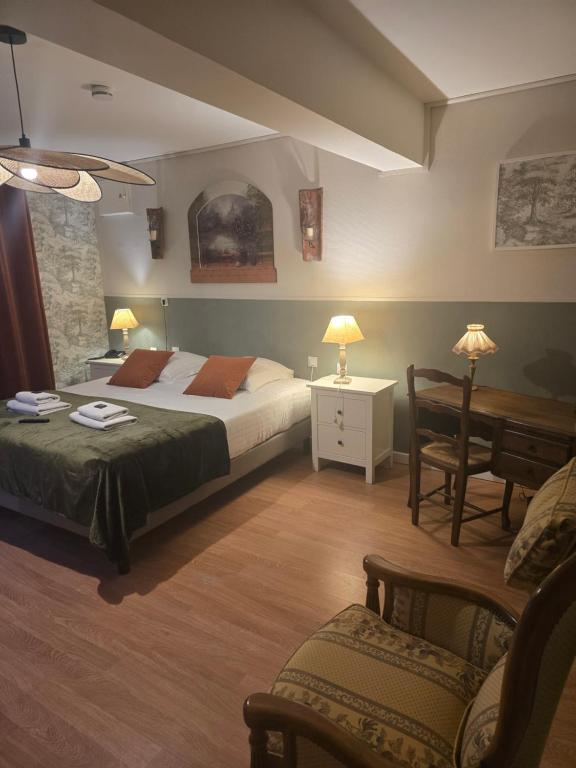 a bedroom with two beds and a table and chairs at Hôtel L'ideal le Mountbatten in Arromanches-les-Bains
