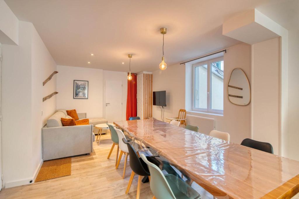 - une salle à manger et un salon avec une grande table et des chaises dans l'établissement La Grande Cordée - Appt au pied des Pyrénées, à Ax-les-Thermes