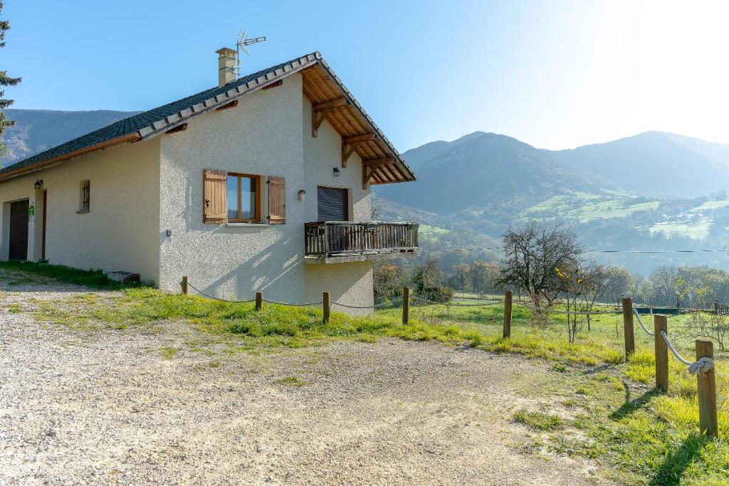 a small house with a balcony and mountains in the background at Superbe Maison Pour 6 Personnes in Saint-Jean-dʼArvey