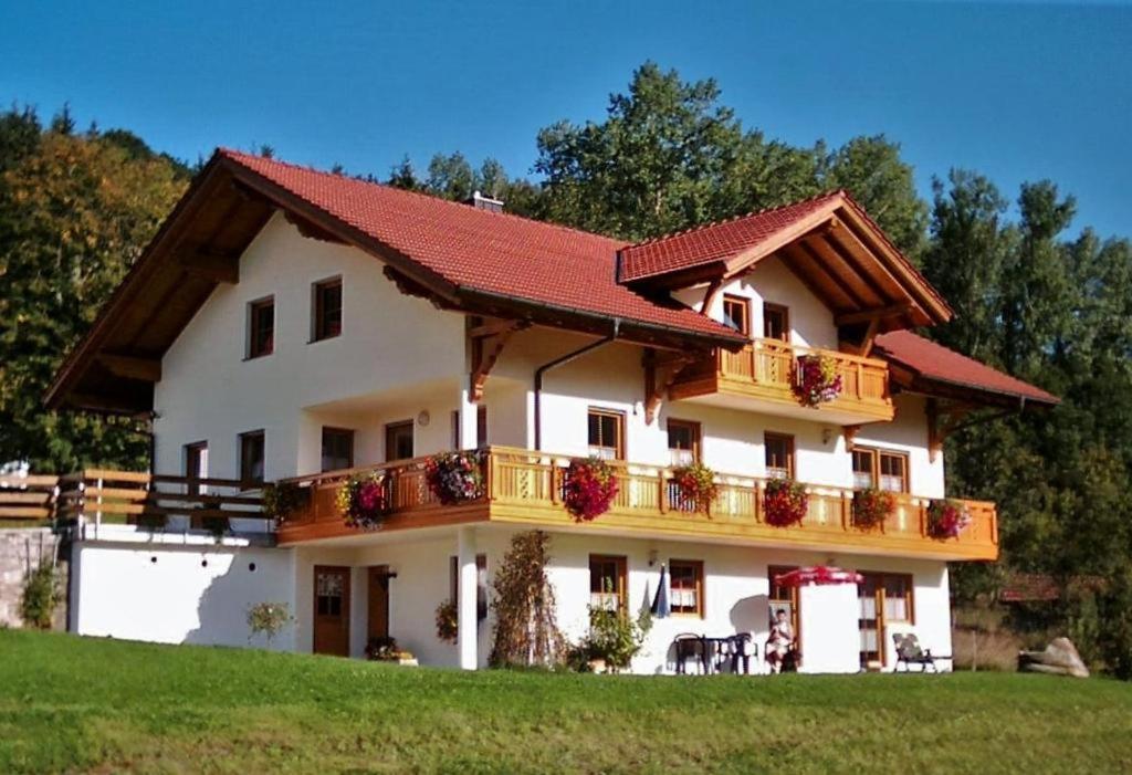 een groot wit huis met een balkon bij Ferienwohnung Lindenhof in Sankt Englmar
