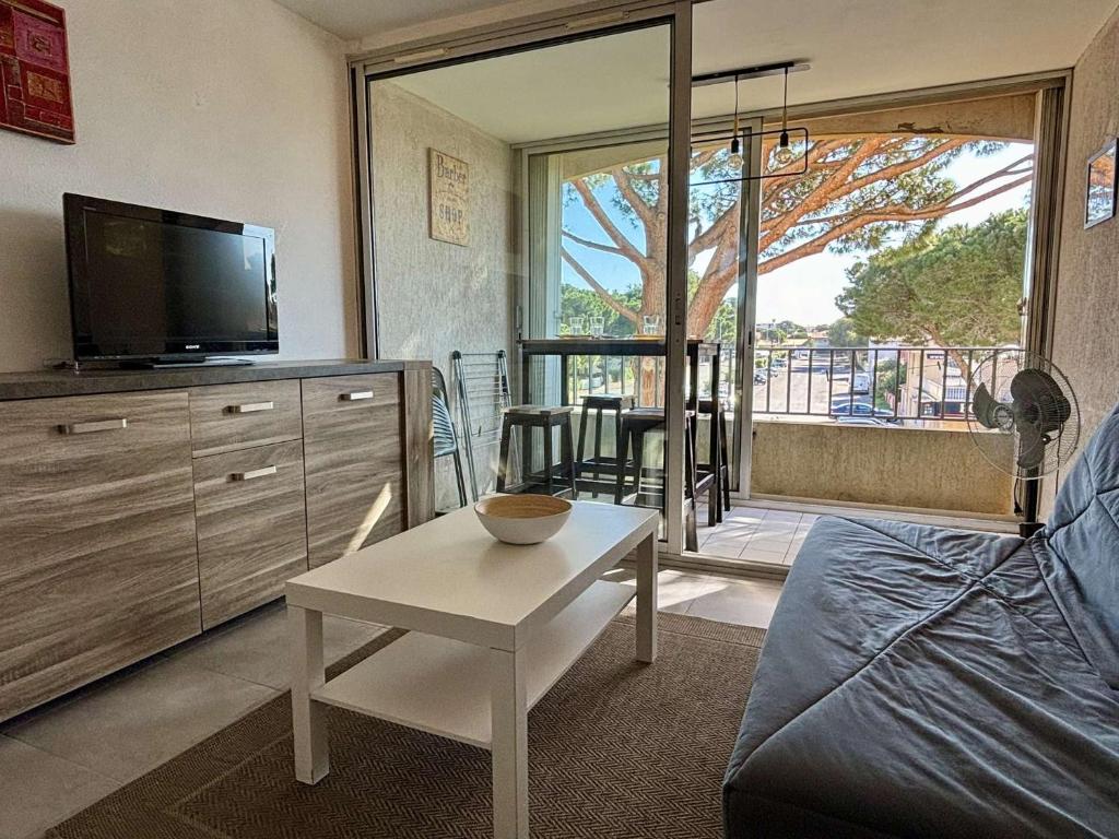 un salon avec une télévision et une table dans l'établissement Appartement studio cabine- Argelès sur mer AR070-202, à Argelès-sur-Mer