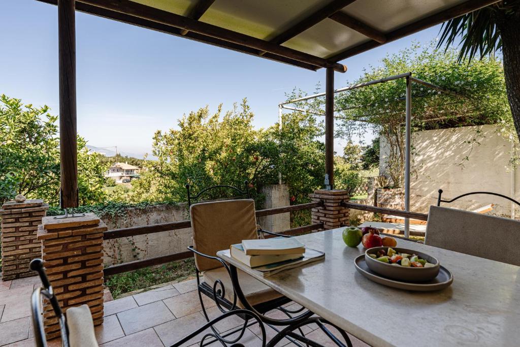 un tavolo con un cesto di frutta su un patio di Ilyessa Cottages a Méson Yerakaríon