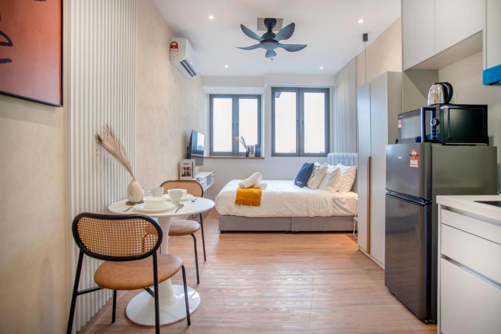 a small apartment with a bed and a table and a kitchen at Riveria City near KL Sentral with 118 view Sky Infinity Pool by COBNB in Kuala Lumpur