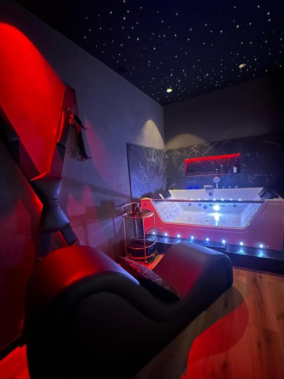 une chambre avec un lit et une baignoire dans une pièce dans l'établissement LoveroomXspa, à Bourg-Saint-Christophe