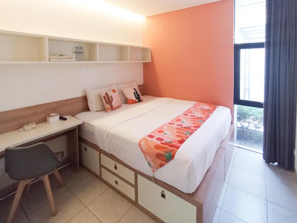 PareにあるOFO Kost Premium Kampung Inggris Pare Syariah Mitra RedDoorzの小さなベッドルーム(ベッド1台、デスク、窓付)