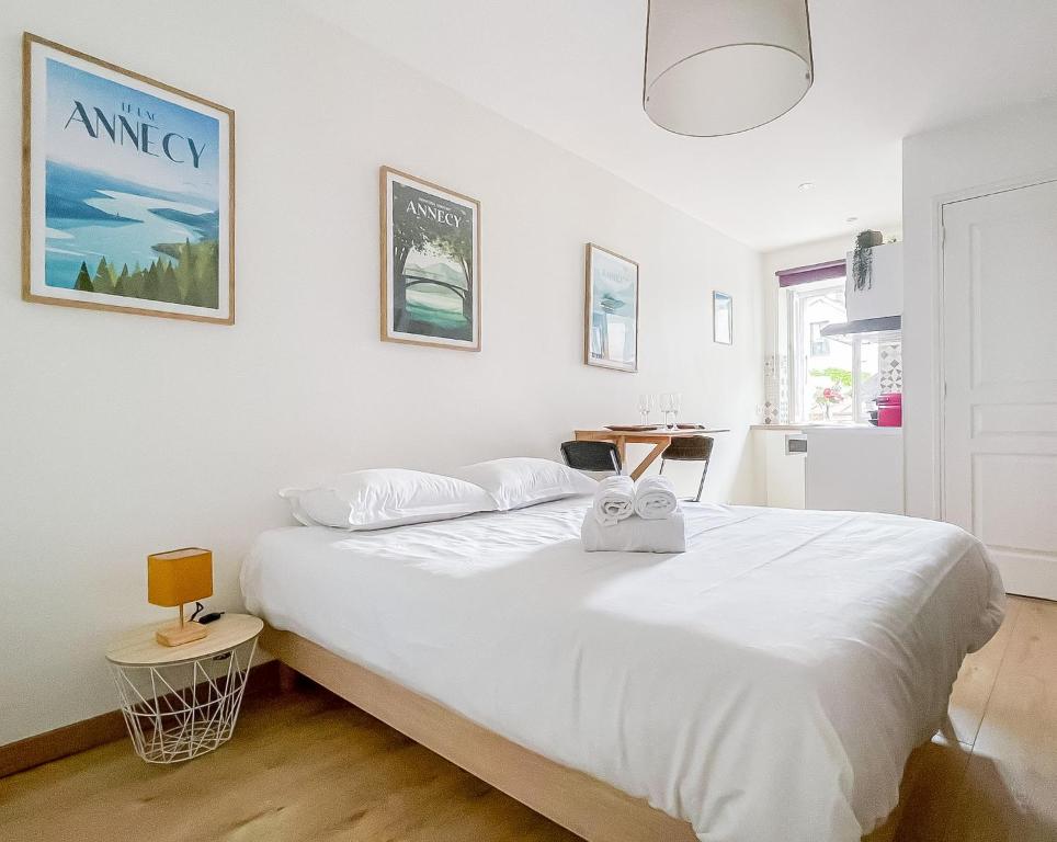 une chambre avec un grand lit blanc dans une pièce dans l'établissement Canopee rue Carnot Annecy, à Annecy