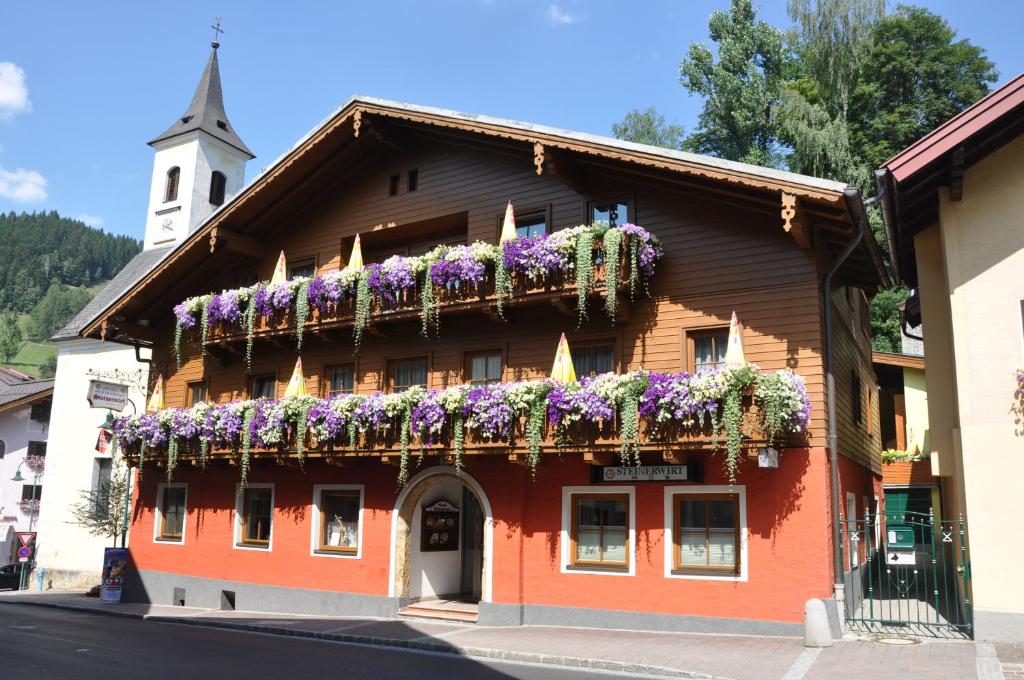 a building with flowers on the side of it at der Steinerwirt in Wagrain