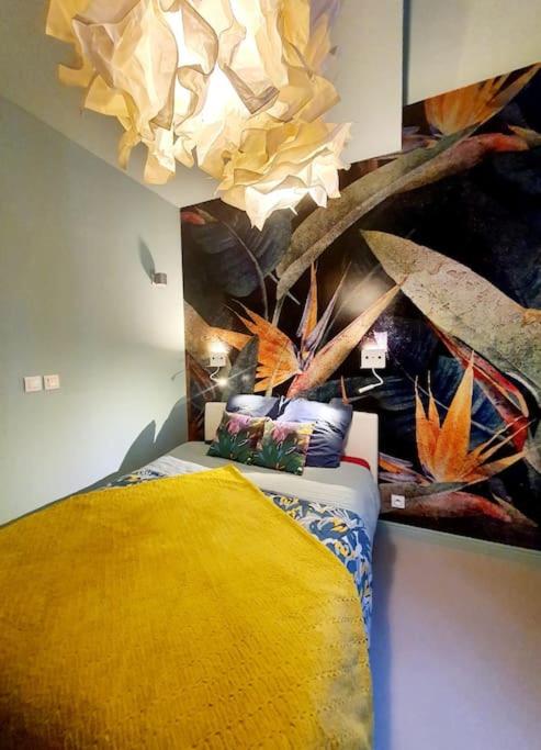 une chambre avec un lit avec une couverture jaune dans l'établissement L'Orée du Parc, Lyon 6 - Parc Tête d'Or, à Lyon