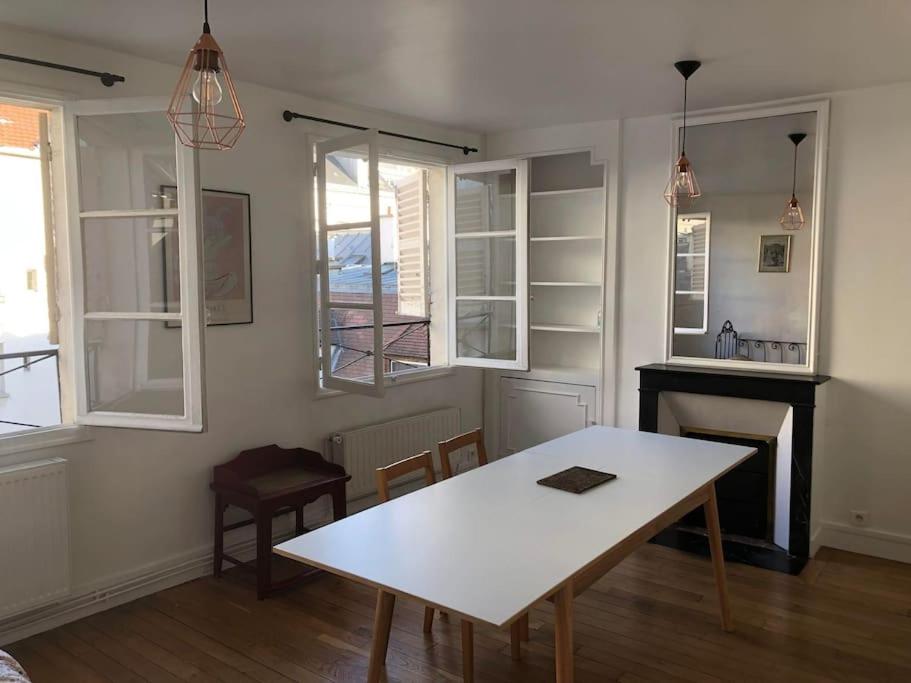 - un salon avec une table blanche et quelques fenêtres dans l'établissement Appartement Paris 5e, à Paris