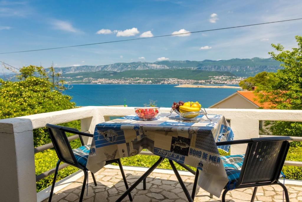 ein Tisch und Stühle auf einem Balkon mit Blick auf das Wasser in der Unterkunft Apartment Andjelko G in Šilo