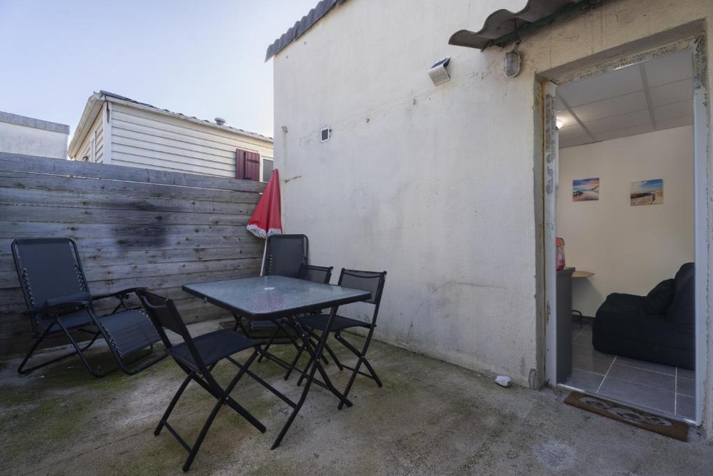 d'une terrasse avec une table et des chaises à côté d'un mur. dans l'établissement Appartement avec terrasse, à La Garde