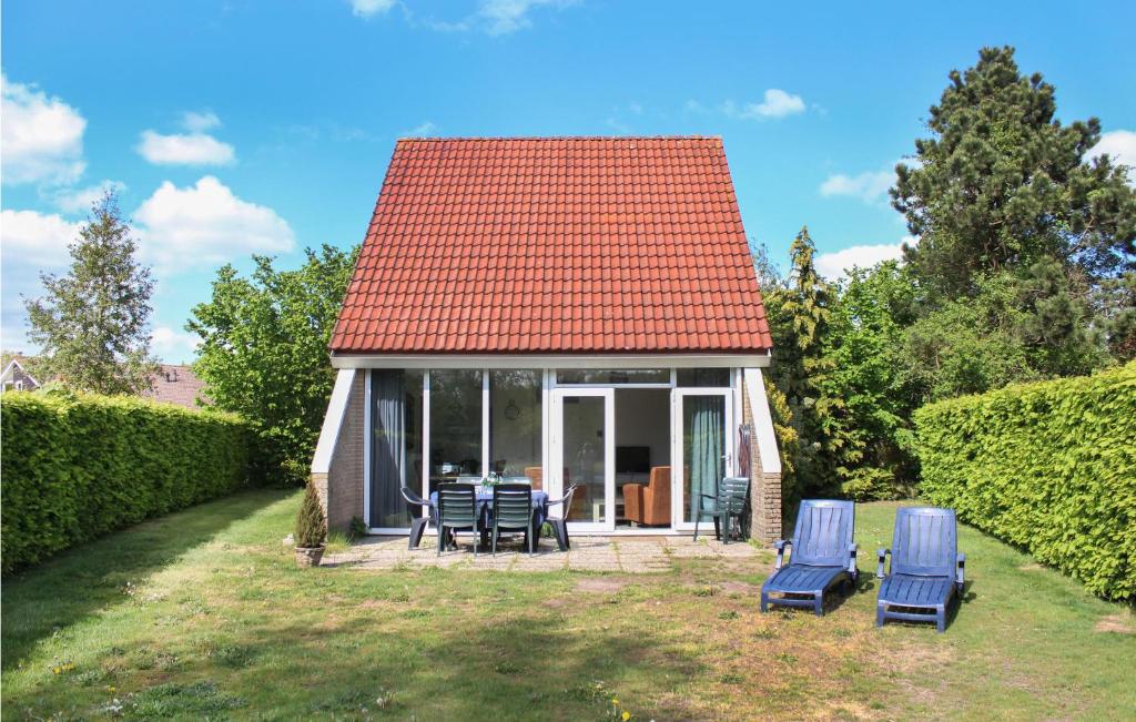 a small house with chairs and a red roof at 3 Bedroom Lovely Home In Vlagtwedde in Vlagtwedde