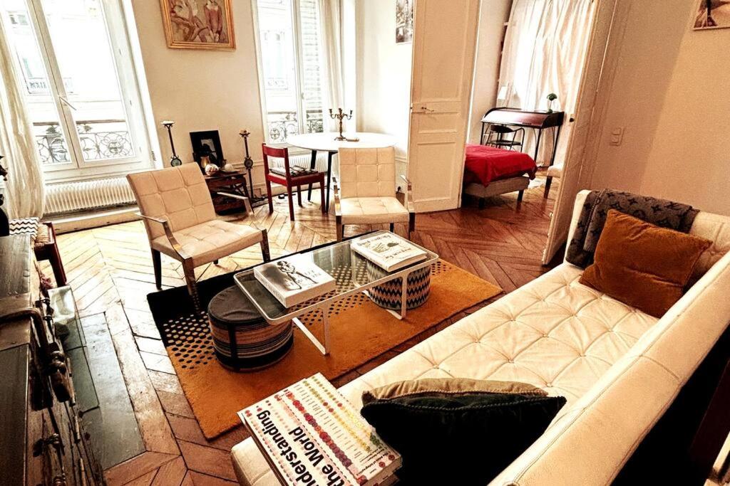 un salon avec un canapé et une table dans l'établissement Central Paris Bohémien and Arty Apt, à Paris