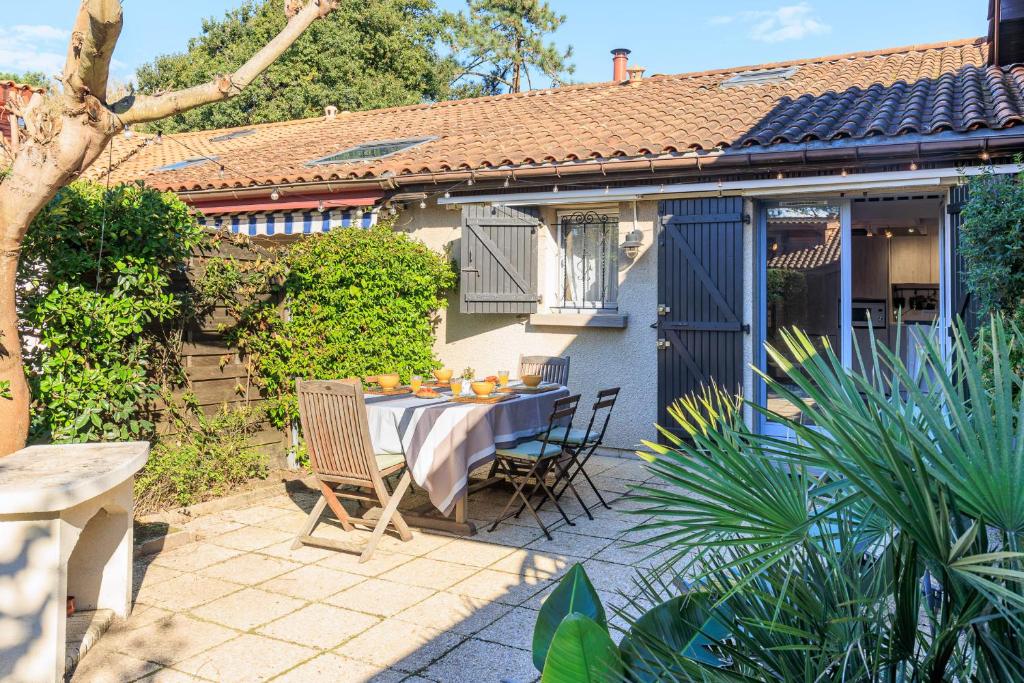 une terrasse avec une table et des chaises ainsi qu'une maison dans l'établissement Maison Kabâna - Welkeys, à Capbreton