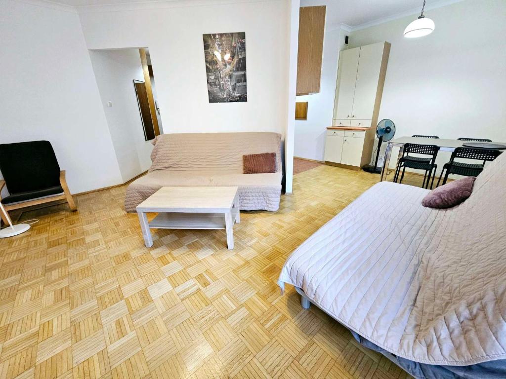 Pokój z 2 łóżkami, stołem i krzesłami w obiekcie Green Kabaty Apartment 1 w Warszawie