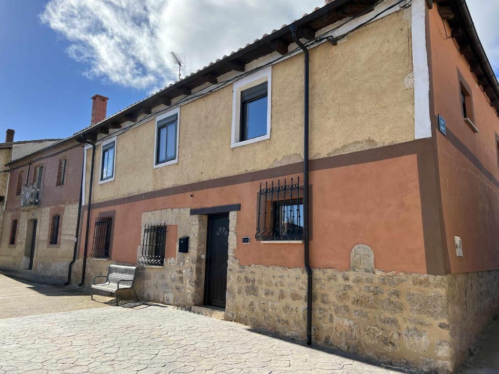 a brick building with a bench in front of it at Fantástica Casa Rural en Castrillo Mota de Judíos in Burgos