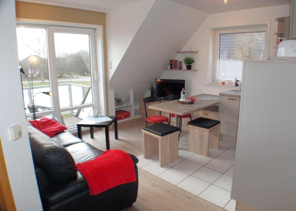 a living room with a couch and a kitchen at Silbermöwe - Sonniger Balkon & Gartenidylle - perfekt mit Hund in Gollendorf