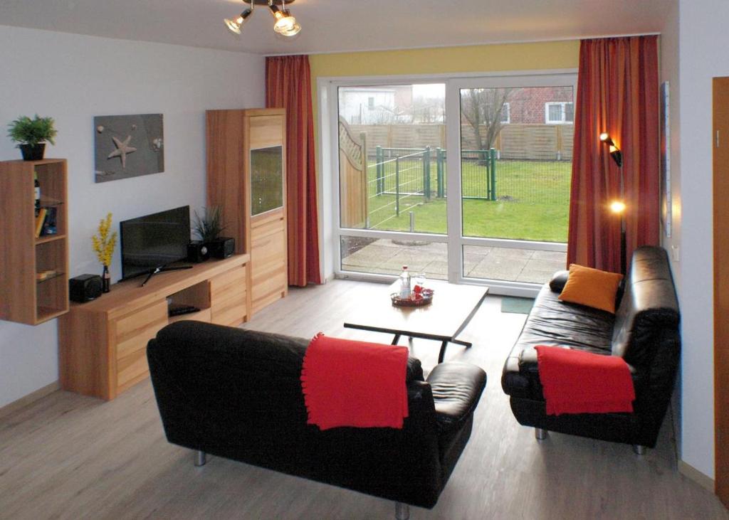 a living room with two couches and a television at Seestern - Wassernah mit Garten und eingezäunter Terrasse in Gollendorf