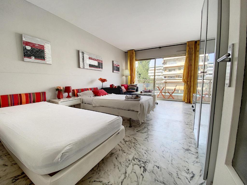 une chambre avec deux lits et un salon dans l'établissement Beau studio 2 personnes LES TUILERIES DRI7, à Cannes