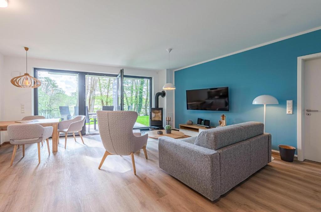 a living room with a couch and a table at Yoga-Oase am Krakower See - Erdgeschoss mit Terrasse, Kamin & Sauna in Krakow am See