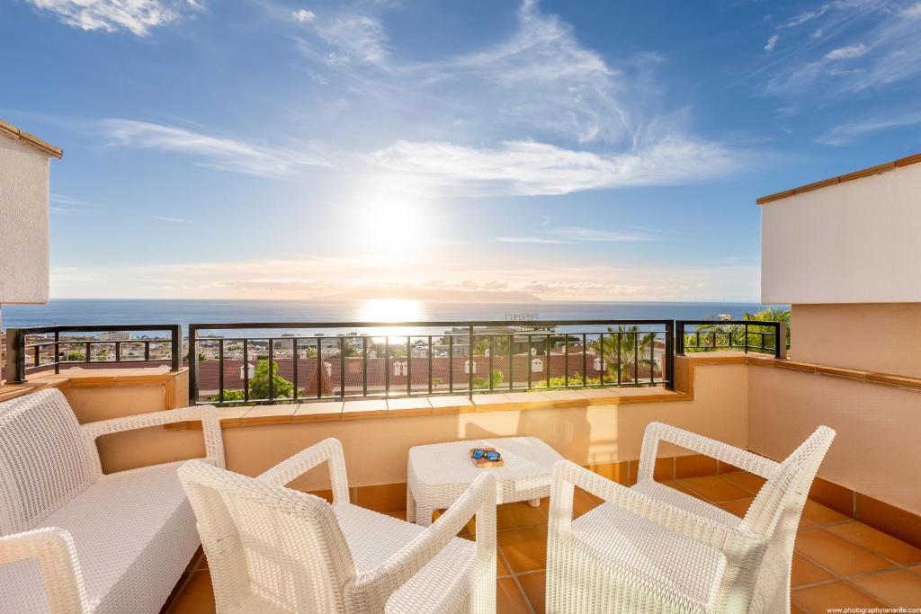 a balcony with chairs and a table and a view of the ocean at Residencial Playa de La Arena in Puerto de Santiago