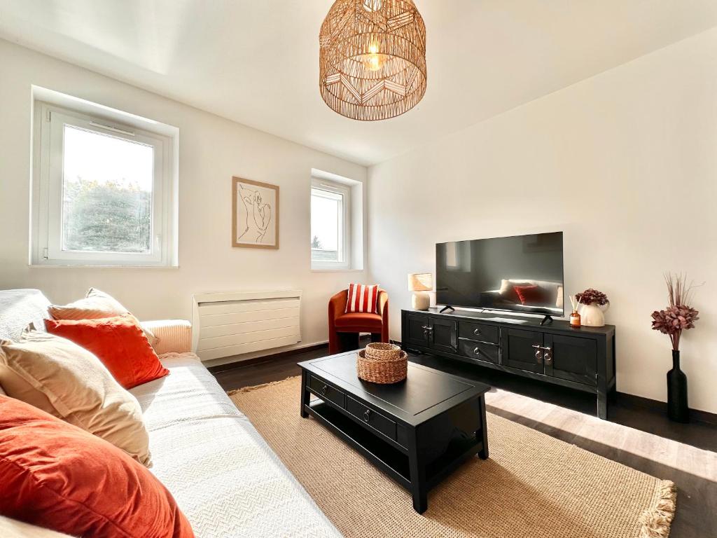 un salon avec un canapé et une télévision à écran plat dans l'établissement Le Bobochic - Calme & Élégance au Cœur de la Ville, à Mont-de-Marsan