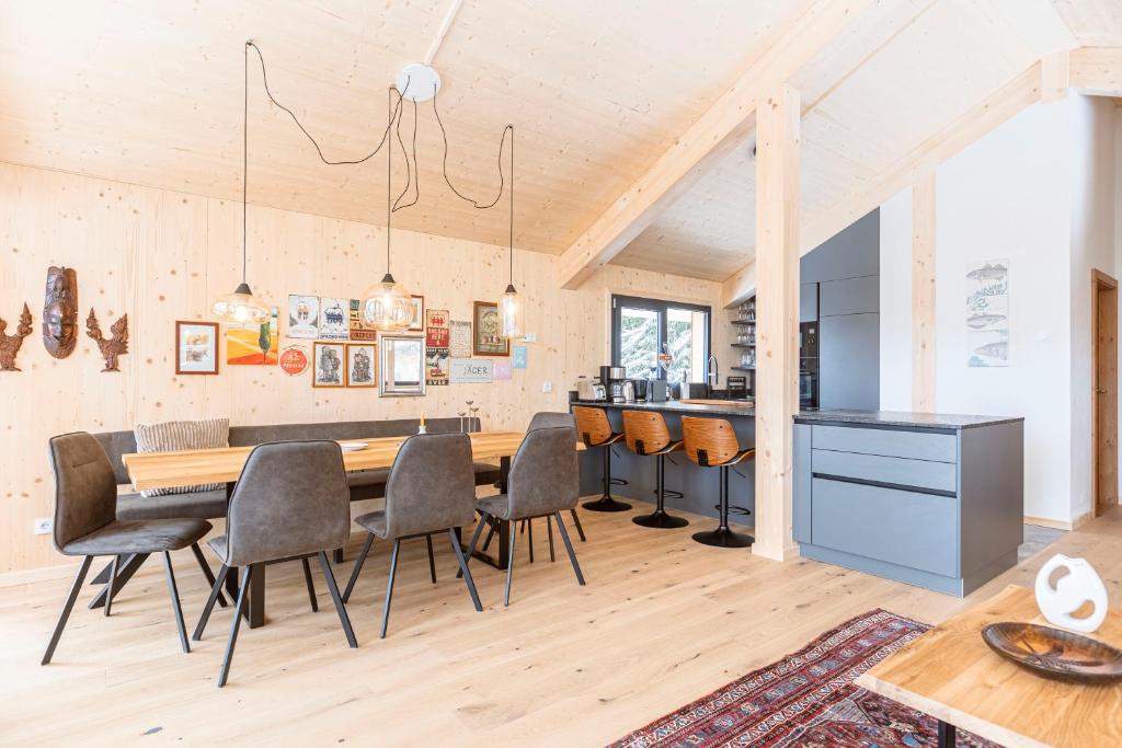 a kitchen and dining room with a wooden table and chairs at Naturchalets Turracher Höhe by ALPS RESORTS in Turracher Hohe