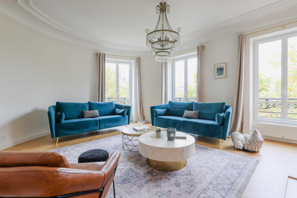 un salon avec des canapés bleus et une table dans l'établissement Luxurious apartment - 4BR-10P- Ternes-Pereire, à Paris