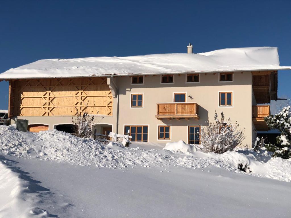 a house with snow on the ground in front of it at Ferienwohnung Thalhammer in Bernau am Chiemsee