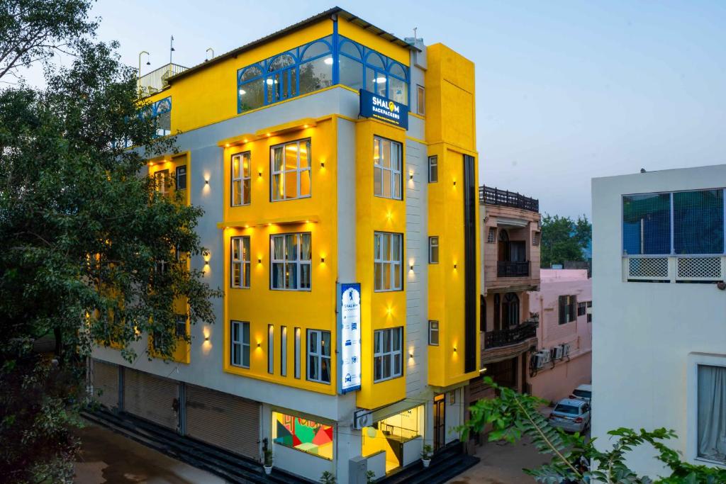 a yellow building with lights on the side of it at Shalom Backpackers Jaipur in Jaipur