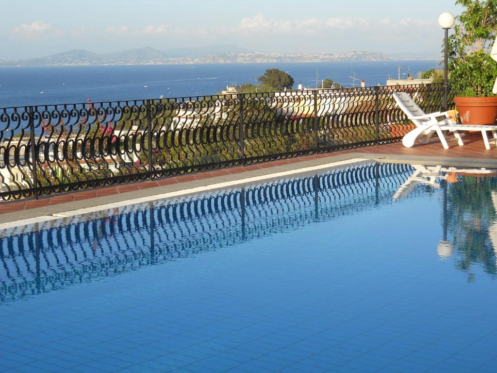 a swimming pool with a chair next to a fence at Villa Gioia in Ischia