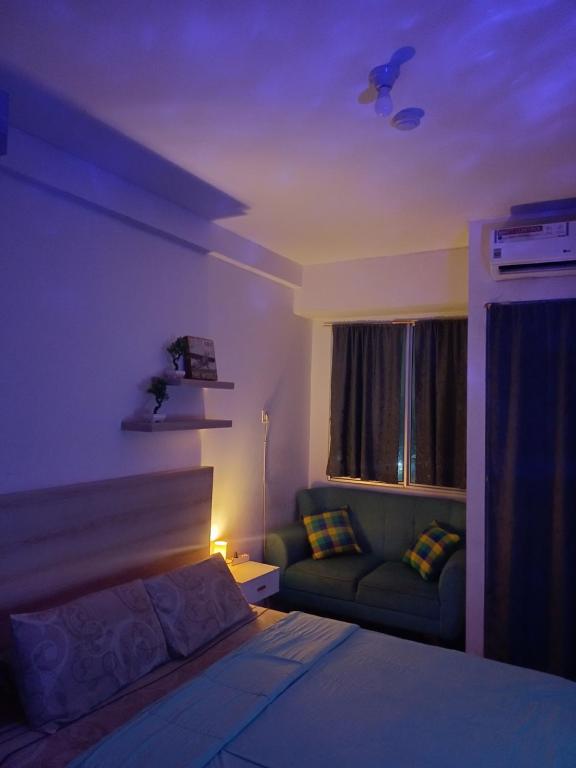 a bedroom with a bed and a couch at Apartemen Riverview Tower Mahakam With Netflix By UVroomsOfficial in Tegalgede