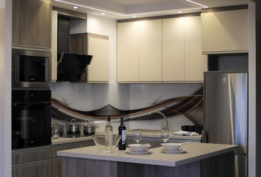 a kitchen with a counter with wine bottles and glasses at Konarskiego Apartments in Słupsk