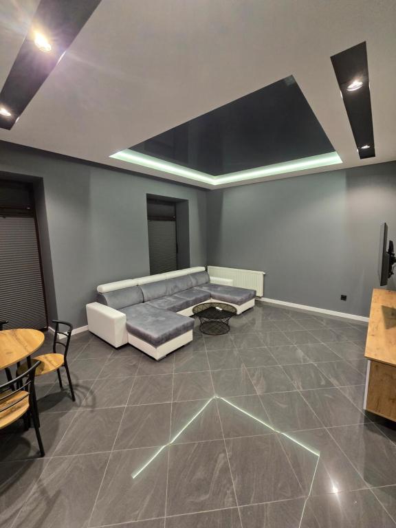 a living room with a couch and a table at Centrum jacuzzi prywatny parking klimatyzacja 1 in Radom