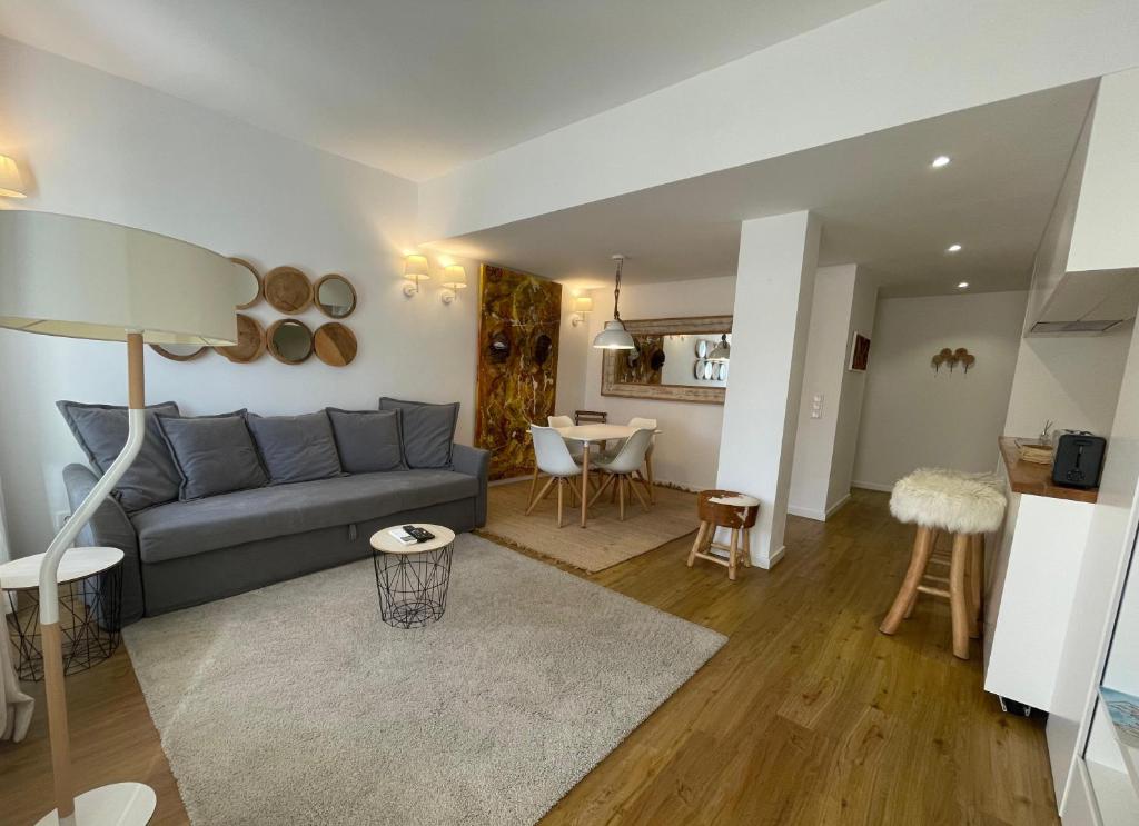 un salon avec un canapé gris et une table dans l'établissement T1 Valbom Cascais, à Cascais
