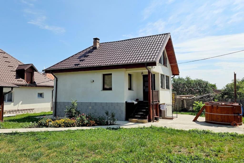 Casa blanca con bañera en un patio en FLH - Livada Bunicilor, en Almaş