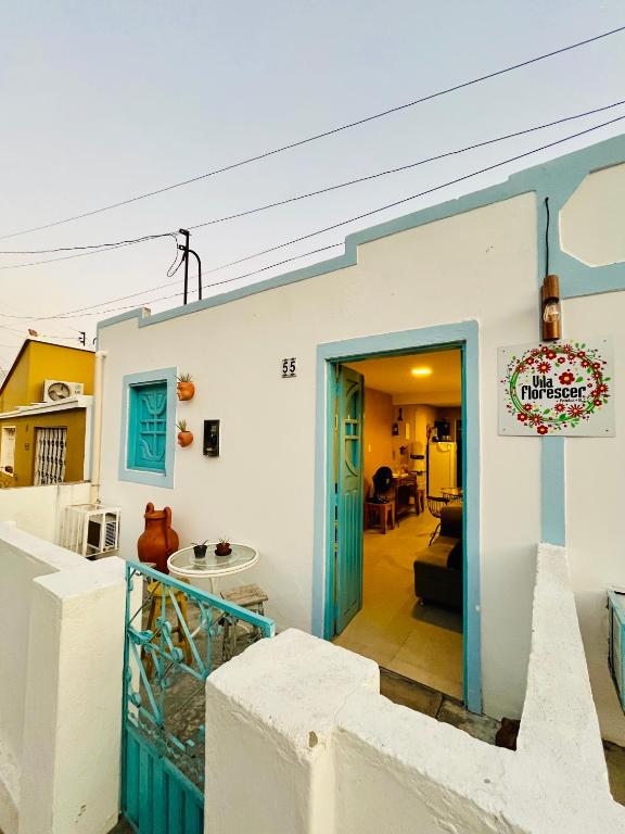 a house with a blue door and a living room at CASA JASMIM, vila florescer, centro histórico!! in Piranhas