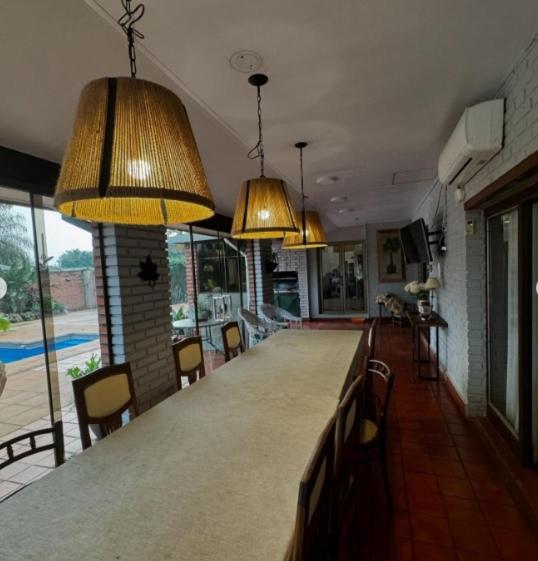 a kitchen with a long bar with chairs and lights at CASONA COMPLETA jn in Posadas