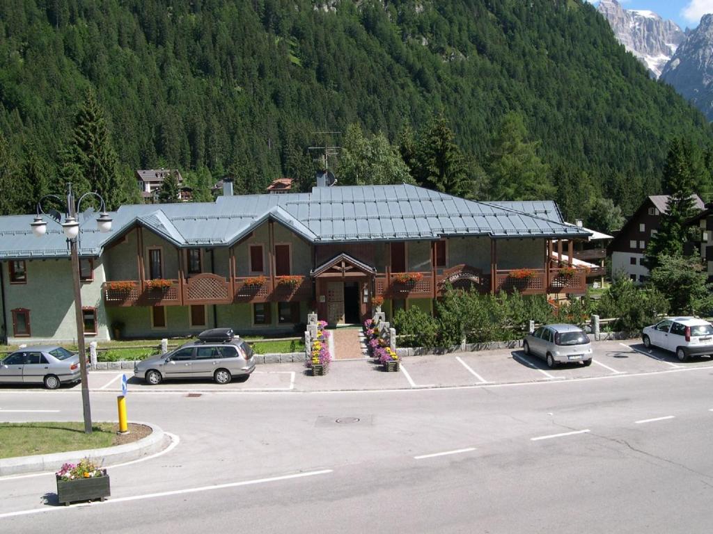 un gran edificio con coches estacionados en un estacionamiento en Residence Orsa Maggiore, en Madonna di Campiglio