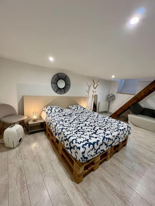 une chambre avec un lit et une horloge au mur dans l'établissement échoppe 2 à 6 personnes, à Bordeaux