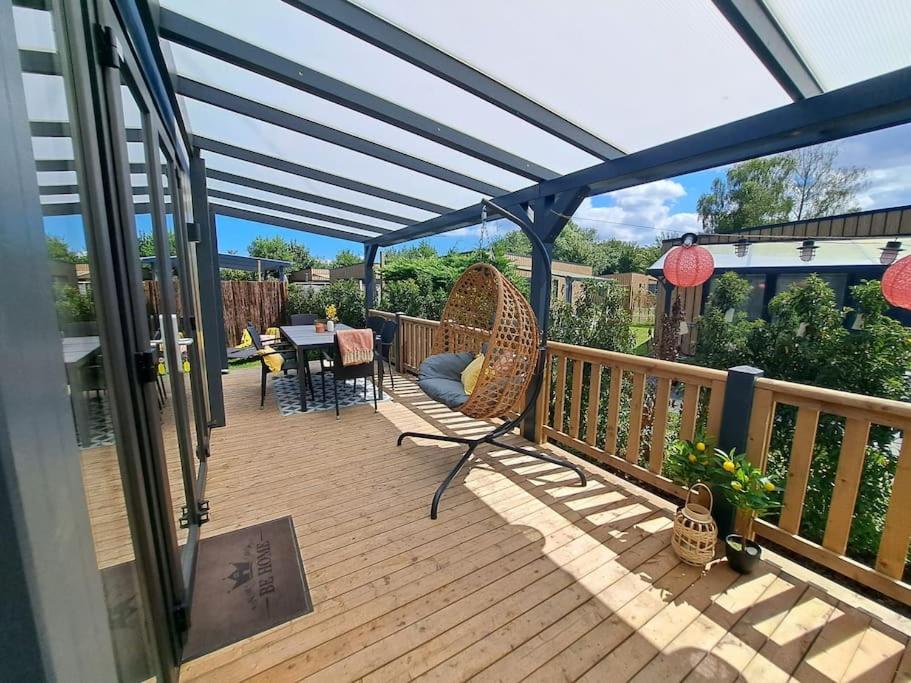 a deck with a pergola and a table and chairs at Villa Present - Chalet Heinkenszand VP006 in Heinkensand