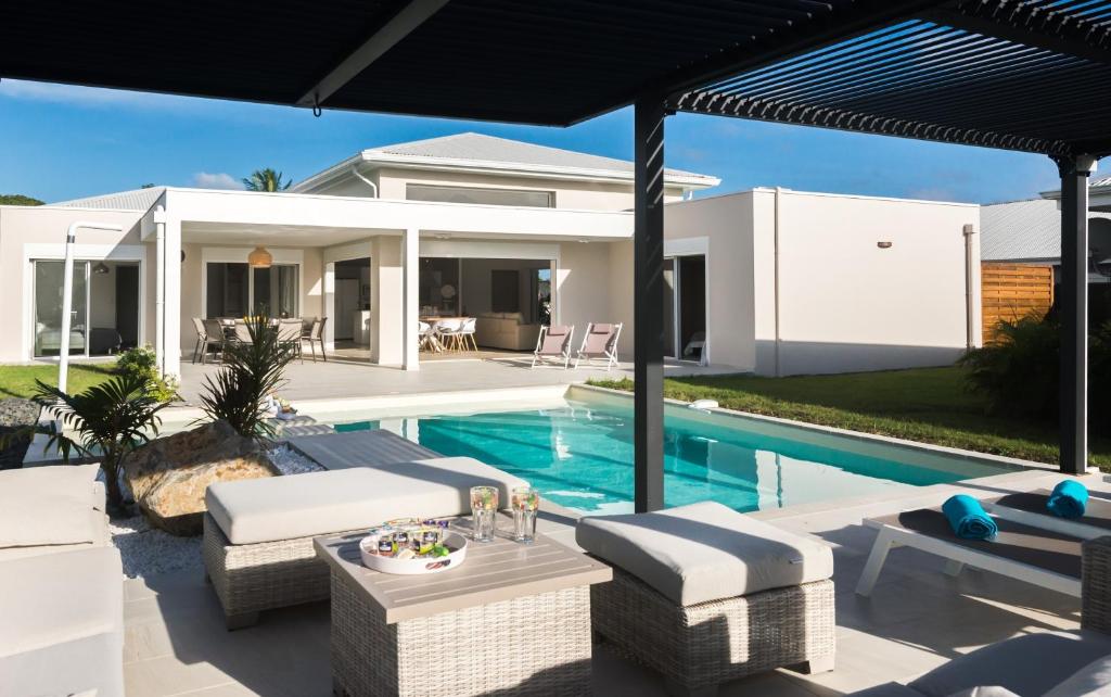 a villa with a swimming pool and a house at Lagon Paradis - 6 Villas individuelles avec Piscine ou Jacuzzi - Loc Voiture Cabriolet ou SUV in Le Gosier