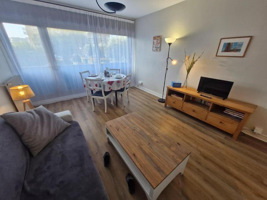 un salon avec un canapé et une table dans l'établissement Les Coquelicots - Fréjus Plage, à Fréjus