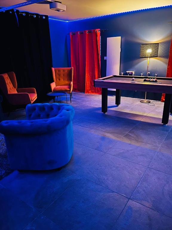 Cette chambre comprend une table de ping-pong et des chaises. dans l'établissement Nos 3 spas de bourgogne (3minutes de Beaune), à Beaune
