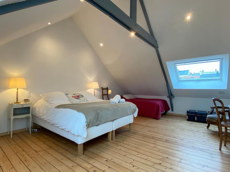 une chambre avec un grand lit dans un grenier dans l'établissement Les Mimosas, plage 200mètres, à Saint-Pair-sur-Mer