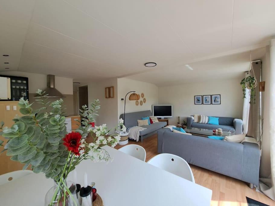 a living room with a table and a blue couch at Villa Present - Chalet Heinkenszand VP008 in Heinkensand