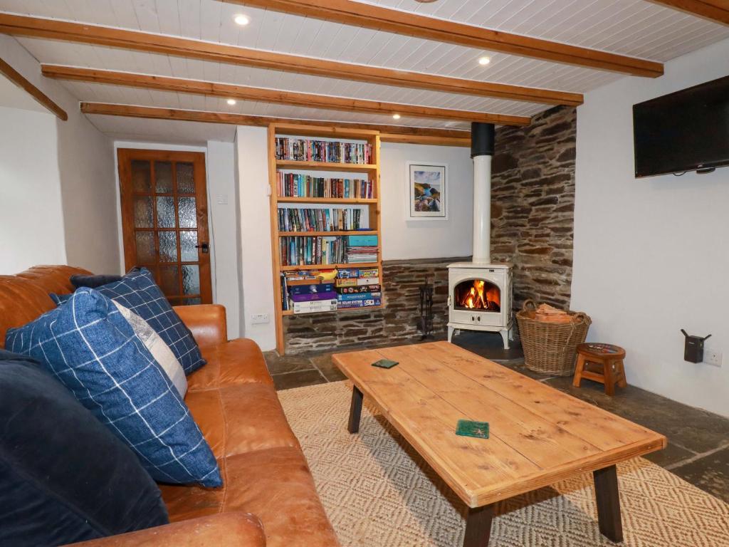 un soggiorno con divano e stufa a legna. di Crab Cottage a Delabole