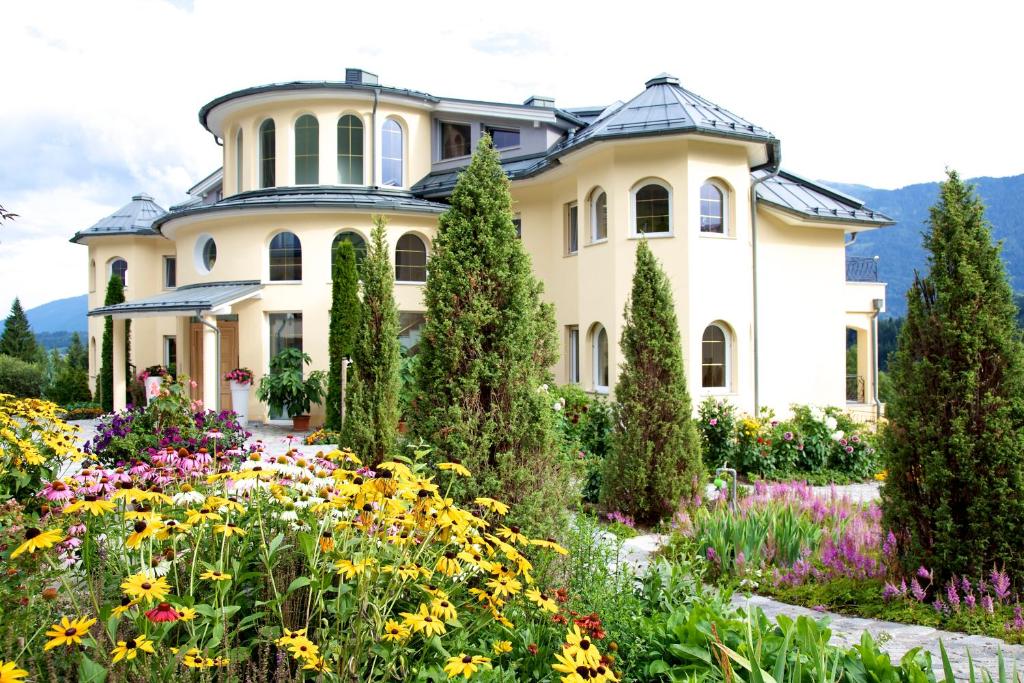 a garden in front of a house with flowers at Villa Victoria in Hermagor