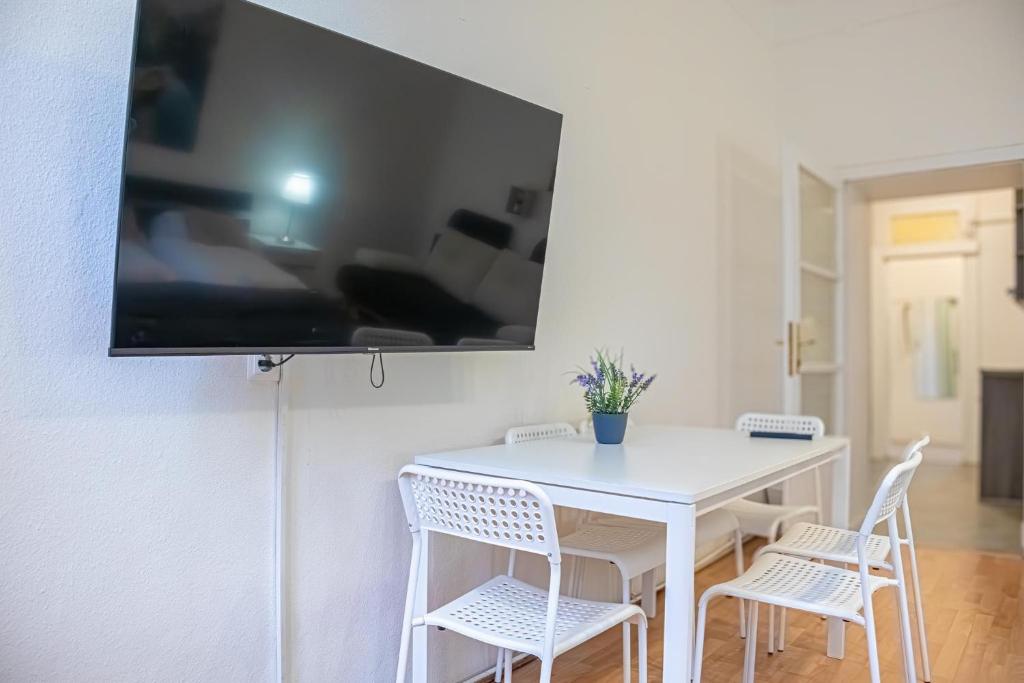 biały stół i krzesła z telewizorem na ścianie w obiekcie Delightful 2BR Apt.-Near Wiener Stadthalle w Wiedniu